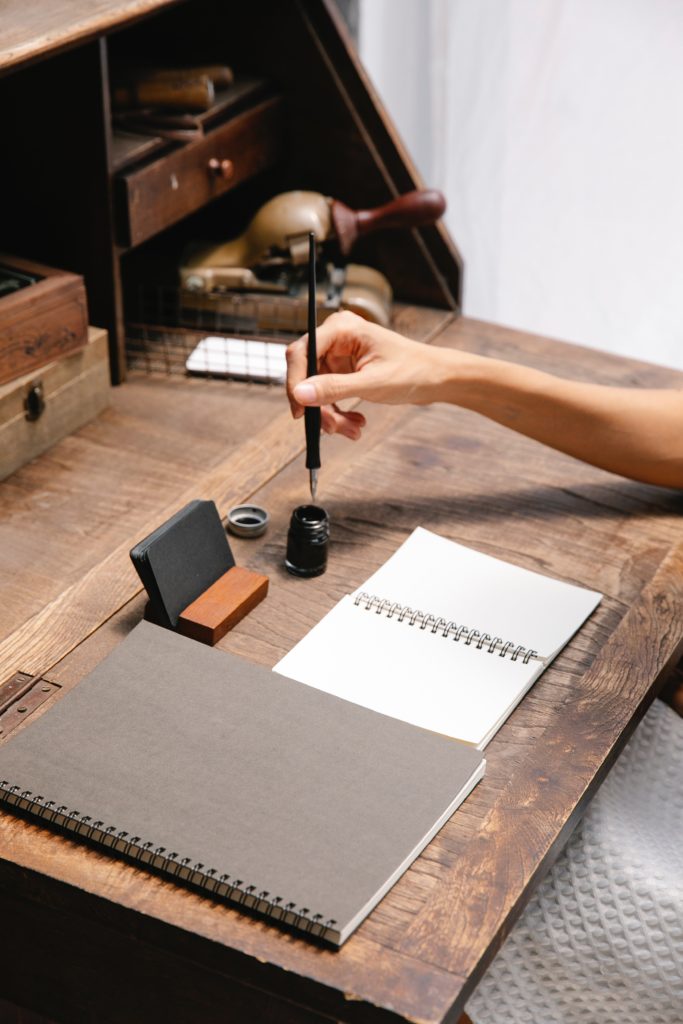 Workspace with small wood desk with ink and calligraphy pen