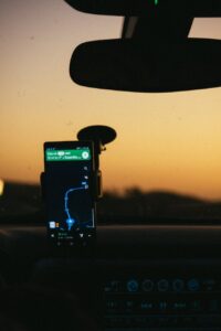 smartphone displaying gps map on holder inside car