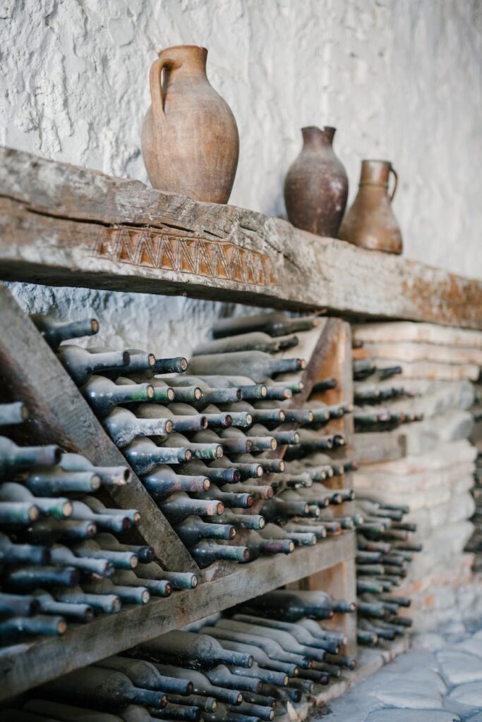 wooden shelves with dusty glass bottles of wine