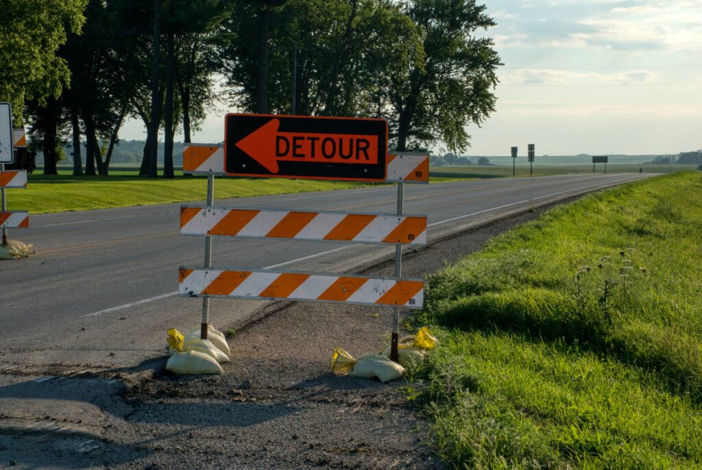 barriers on asphalt road with a road sign indicating a DETOUR