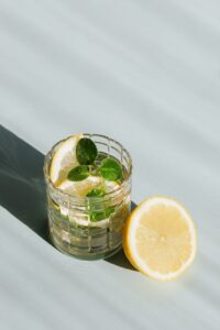 glass of refreshing drink with mint and lemon on table served at in-person event.