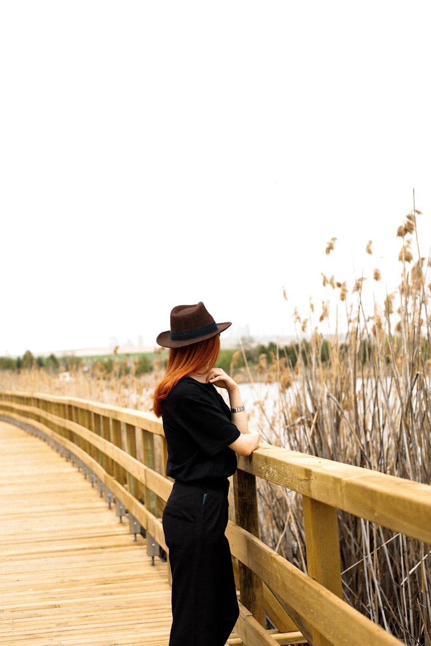 woman in hat and black blouse on lakeshore
