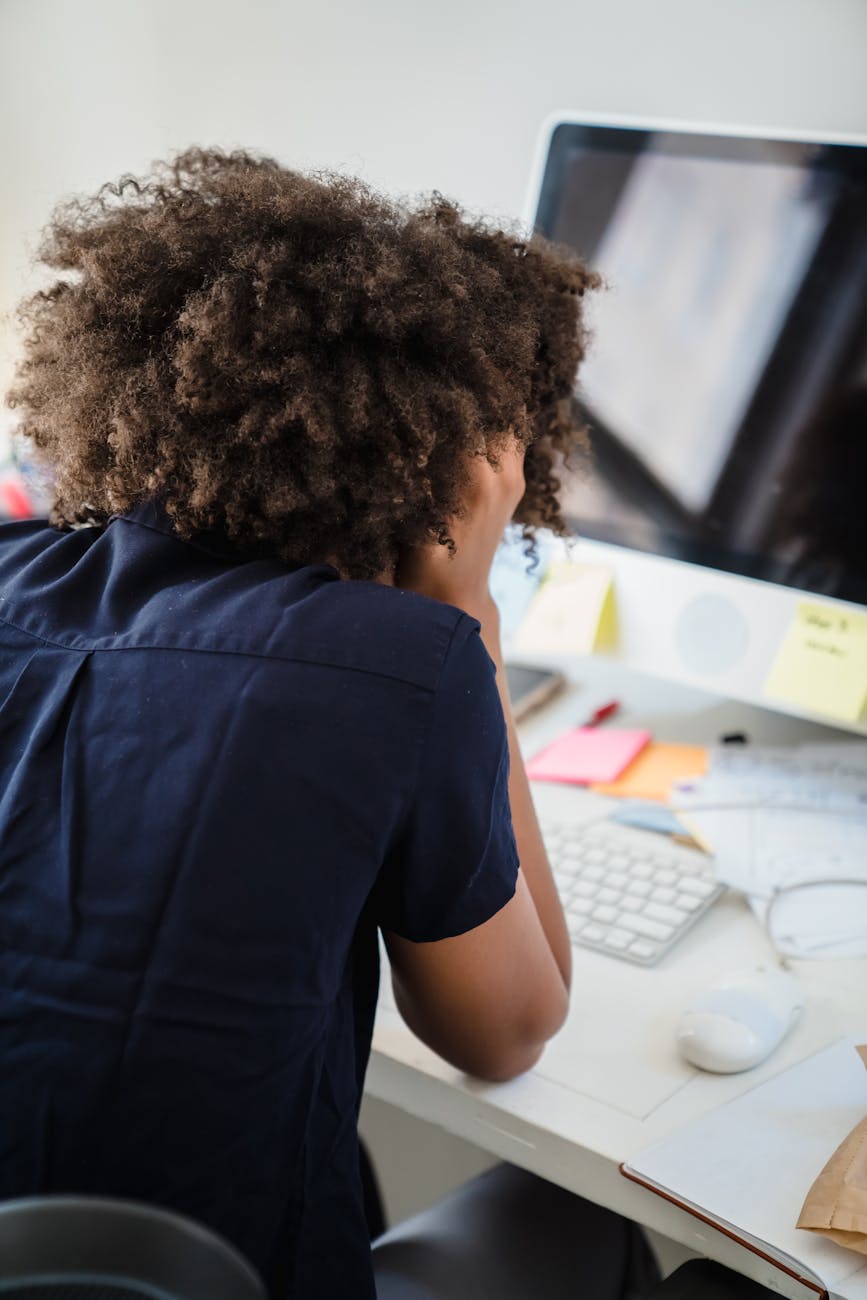 Businesswoman sitting at a desk suffering from overwhelm and burnout