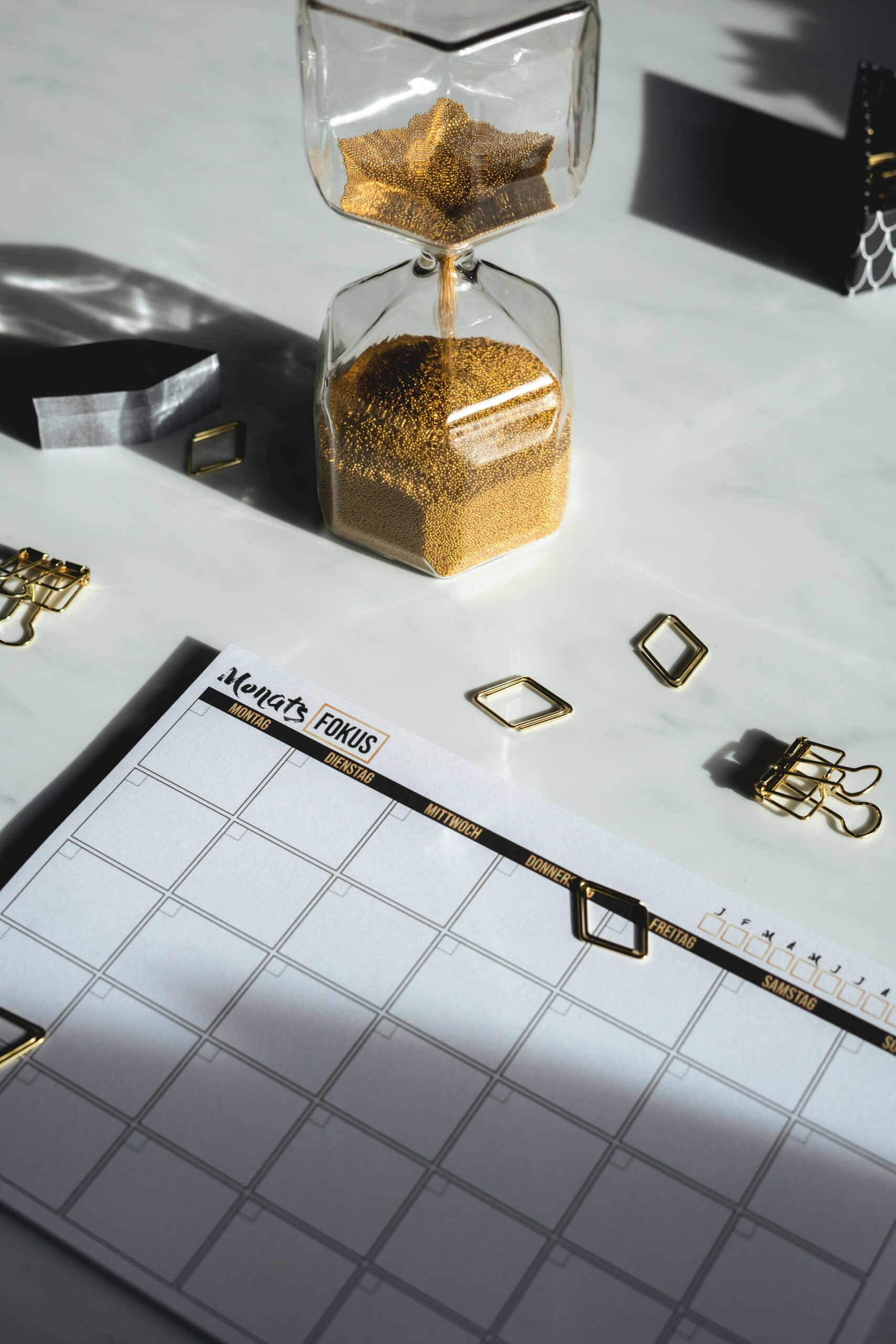 Blank calendar with hourglass represents being overwhelmed when planning retreat decisions