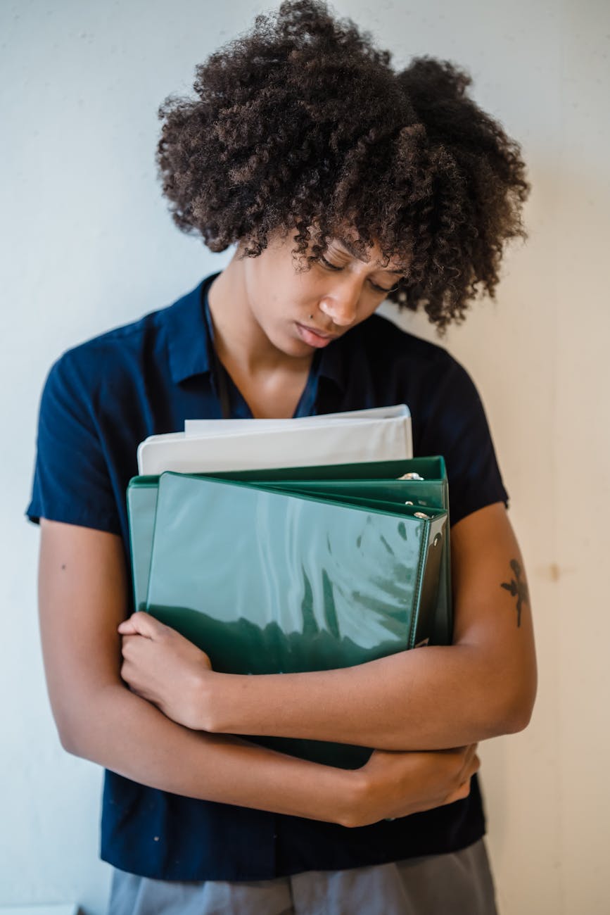 female office worker holding a green binder with documents